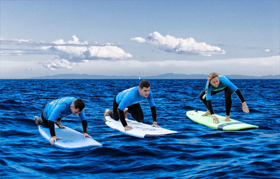 Chicos y chicas aprendiendo a hacer surf.